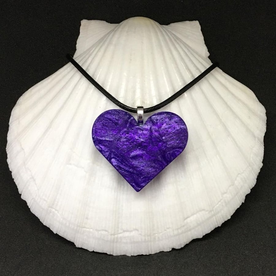 Purple heart pendant on black cord chain.
