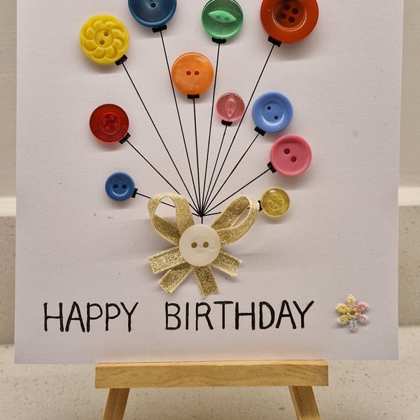 Happy birthday card of buttons as balloons tied with gold ribbon hand drawn 