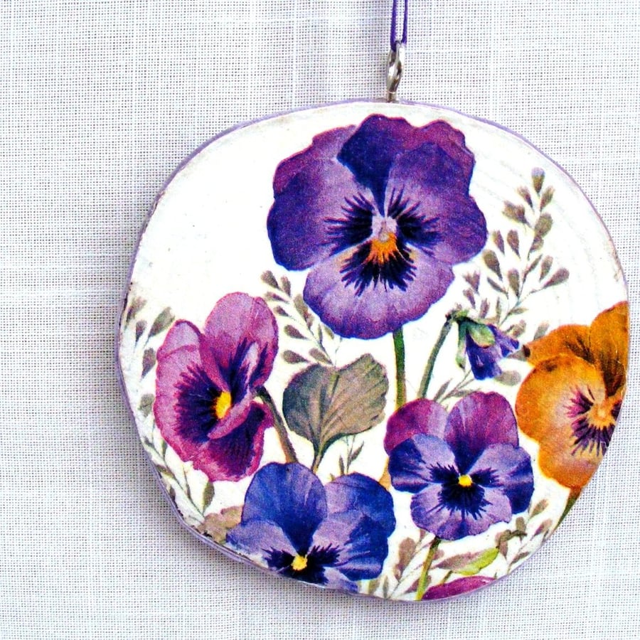 Pansy decoupaged log slice wall decoration.