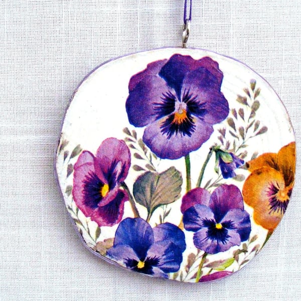 Pansy decoupaged log slice wall decoration.