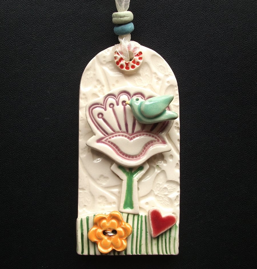 Ceramic tag decoration with bird and flower button