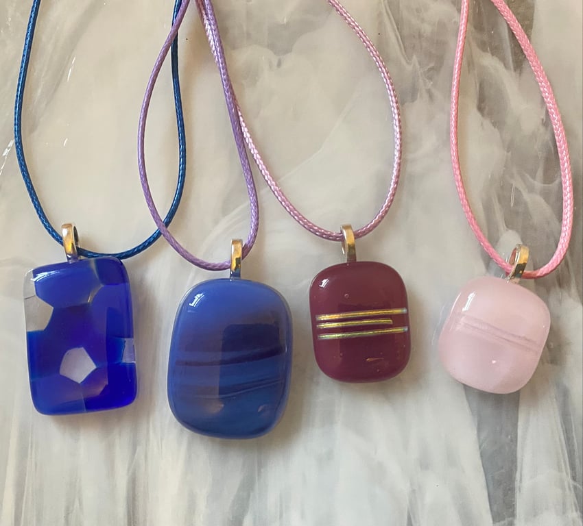 Four handmade fused glass pendants in pinks and purples