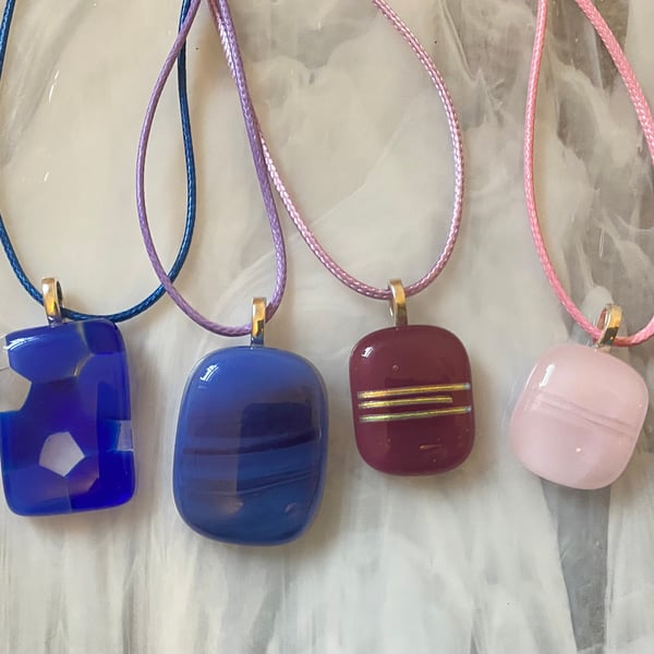 Four handmade fused glass pendants in pinks and purples