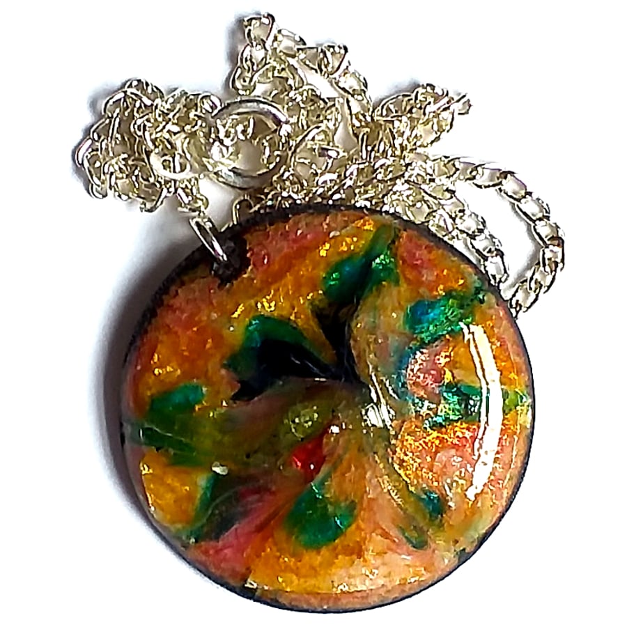 round pendant decorated with scrolled enamel shot