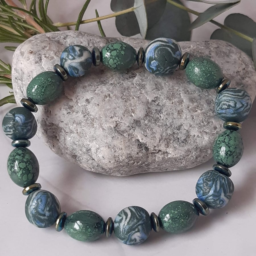Handmade polymer clay bracelet in a forest green and ice blue mix
