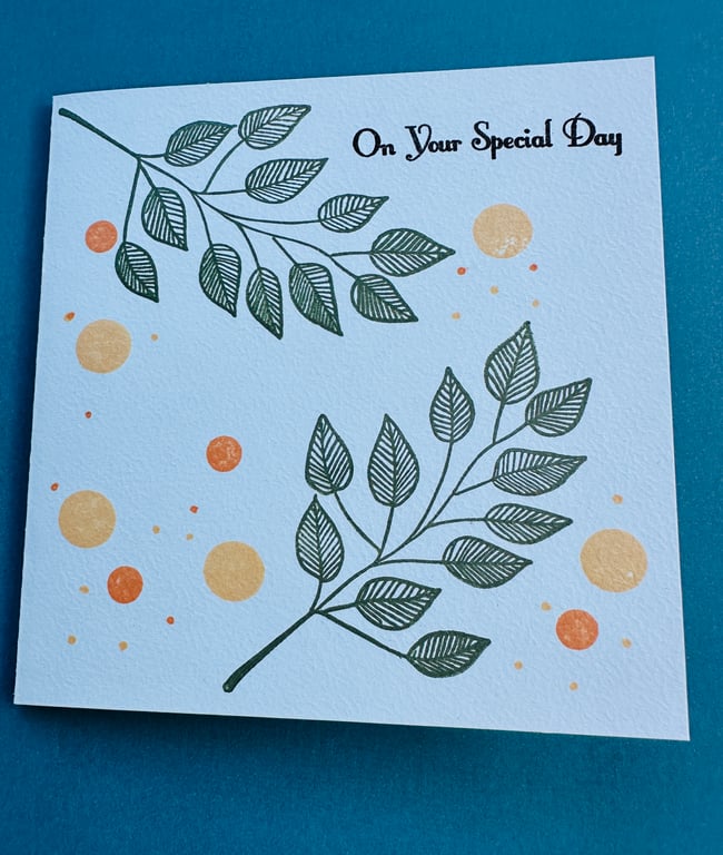 A pastel blue card,  leaves and florals and the greeting “on your special day”