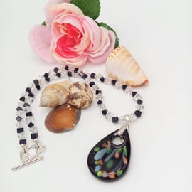  A Black and Clear Cube Bead Necklace with a Black Teardrop Shaped Glass Pendant