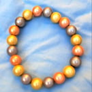 Disco bead bracelet, orange, yellow and silver elasticated