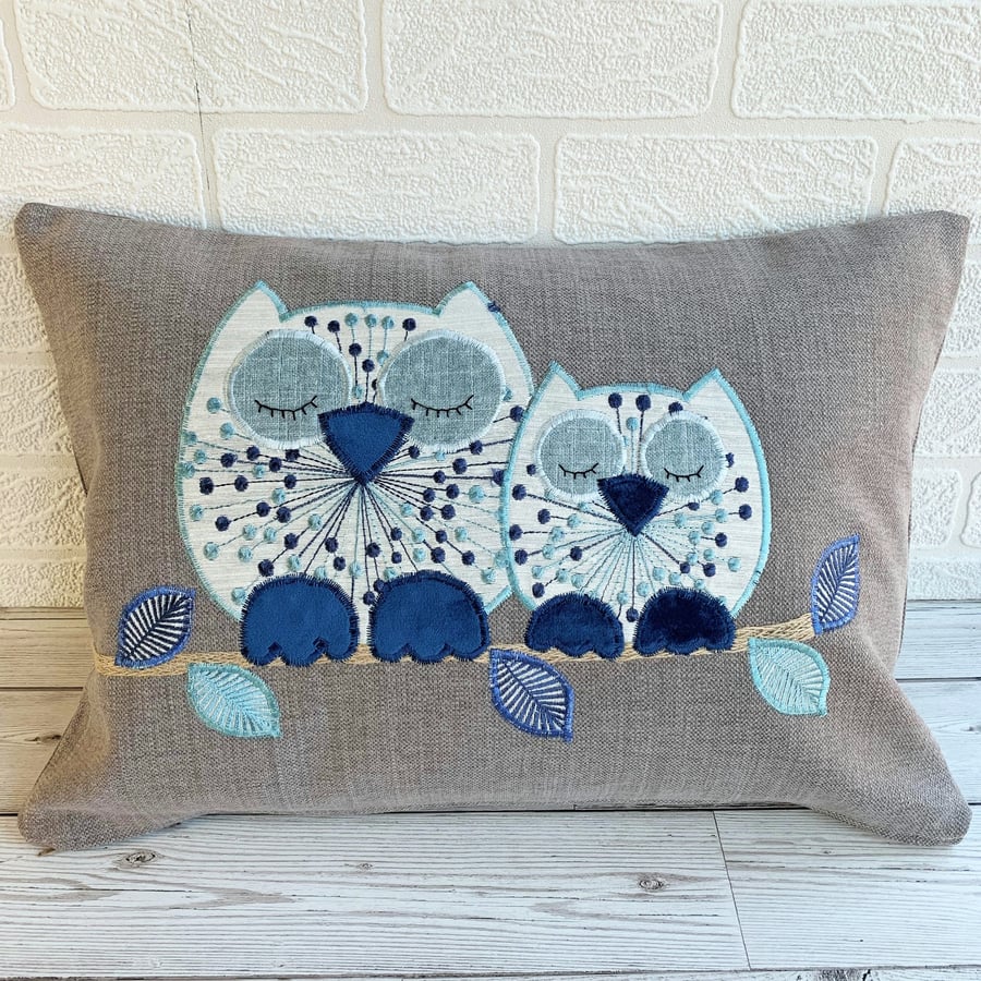 Sleepy owls cushion with cream and blue owls on a taupe cushion