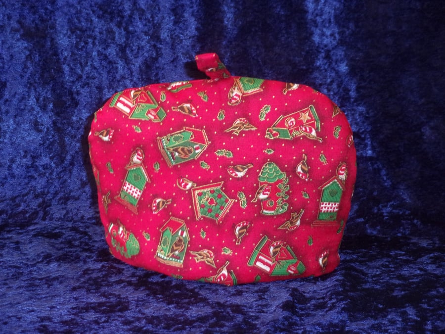 Small Tea Cosy with Decorated Bird Houses on a red background