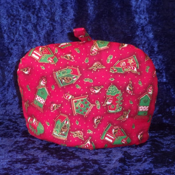 Small Tea Cosy with Decorated Bird Houses on a red background
