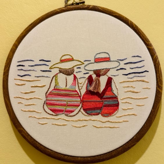 Hand embroidered art, friendship on the beach, seaside holiday themed. Pride