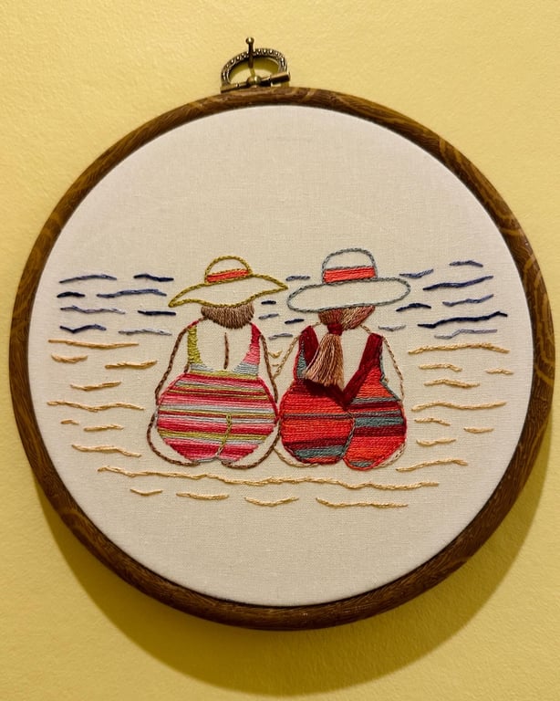 Hand embroidered art, friendship on the beach, seaside holiday themed. Pride