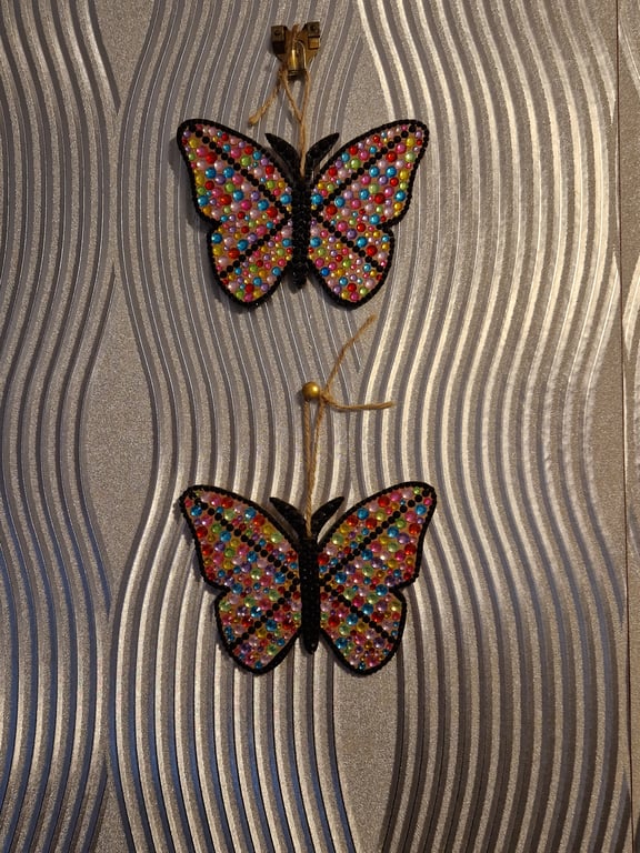 A pair of small hand decorated sequinned butterflies.