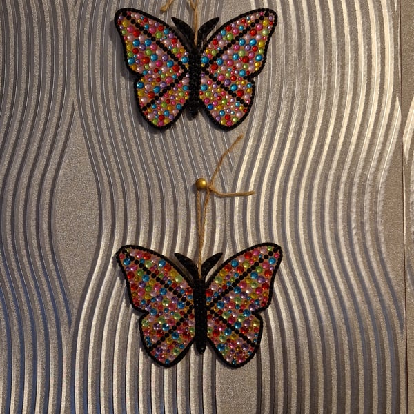 A pair of small hand decorated sequinned butterflies.
