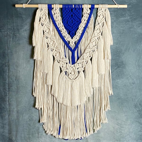 Macrame wall hanging with intricate knot design, royal blue and beige colours