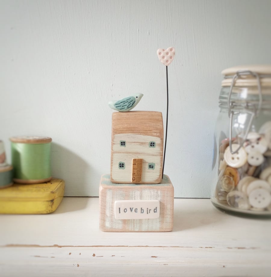 Wooden painted house with clay bird and love heart 'lovebird'