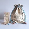 Drawstring bag upcycled in a vintage tea towel printed with embroidery stitches