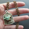 Bird in a cage ceramic pendant