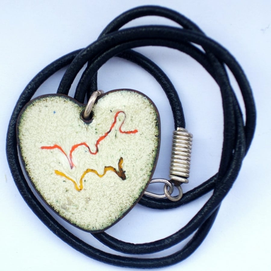 heart pendant, scrolled red and yellow on cream, on a thong