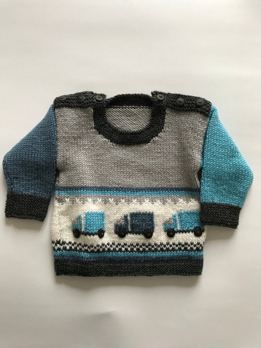 Hand knitted baby jumper with a lorry design