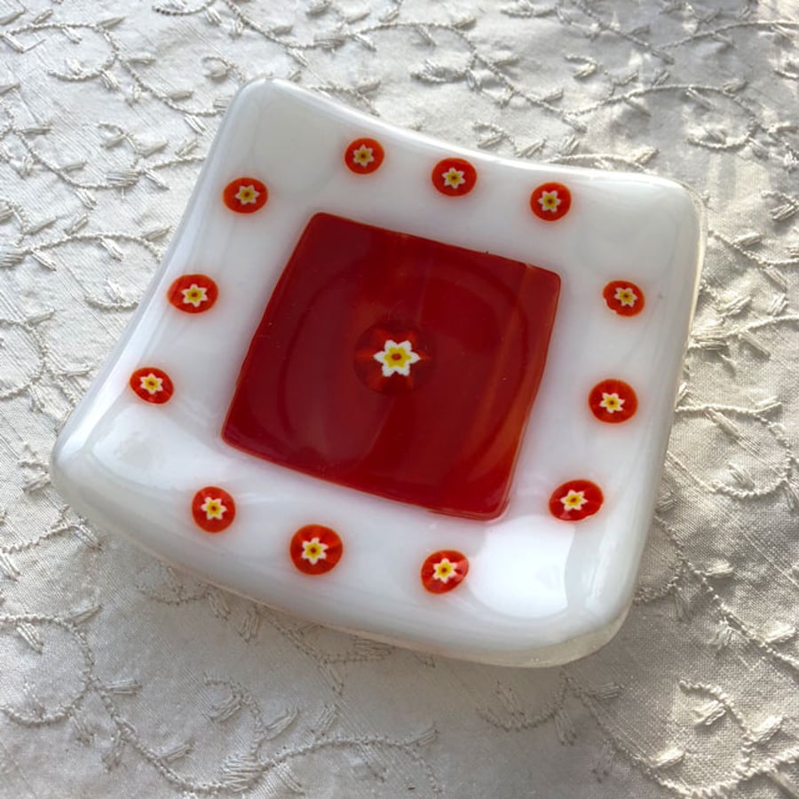 White and orange fused glass trinket dish with inset millefiori (little flowers)