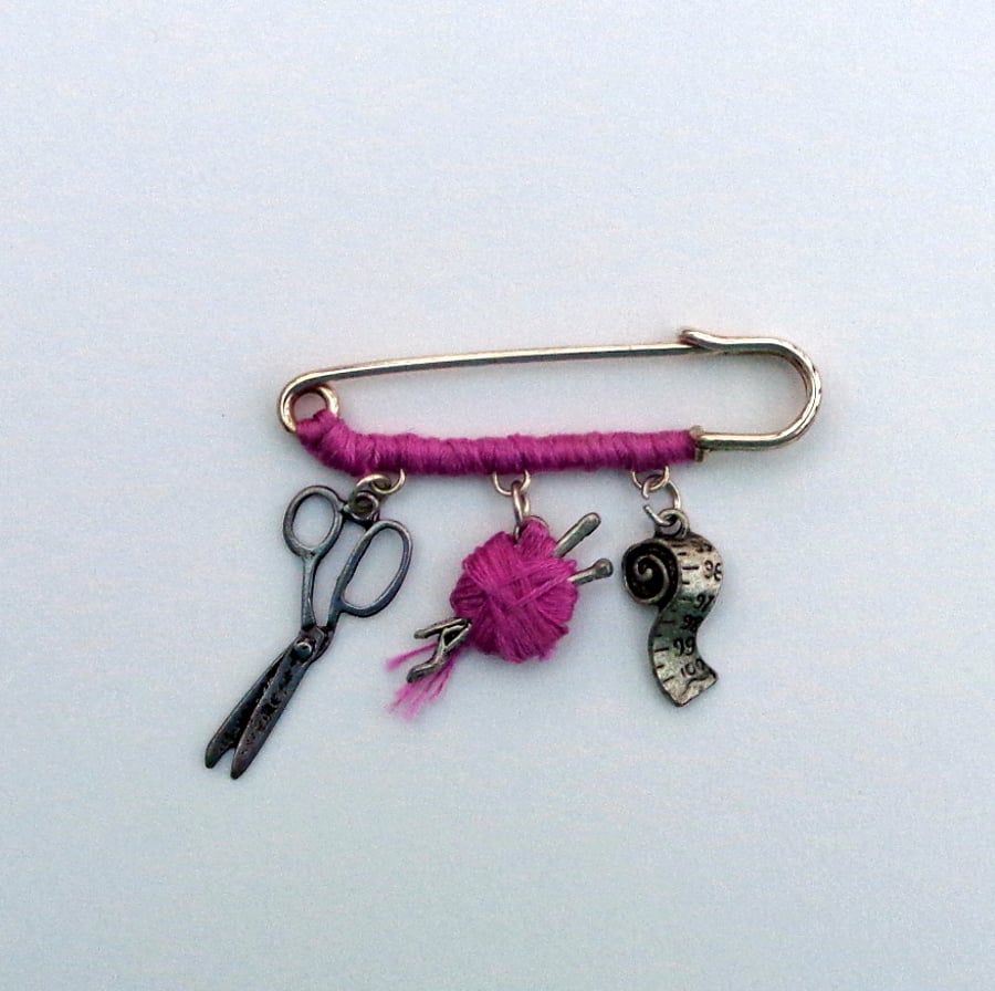 Kilt-pin brooch with knitting charms