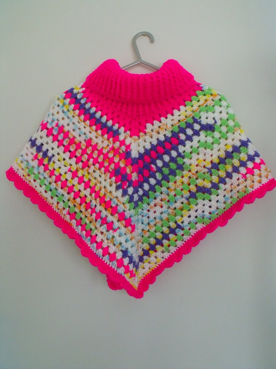 girls crocheted roll neck poncho in bright pink and multicoloured yarn, 8-10y
