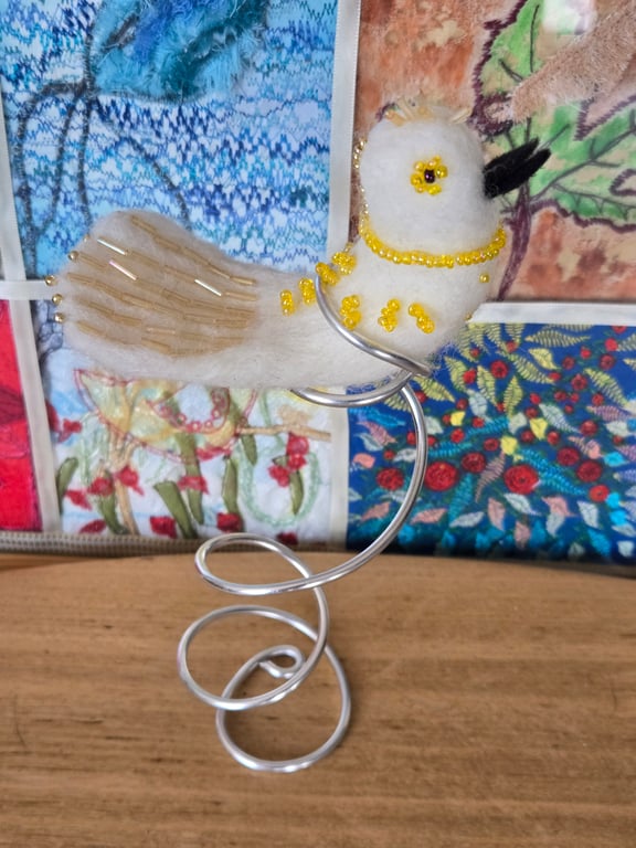 Charlotte, the needle felted, sparkling bird sat on a silver tree