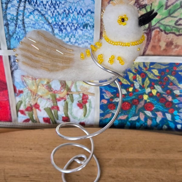 Charlotte, the needle felted, sparkling bird sat on a silver tree