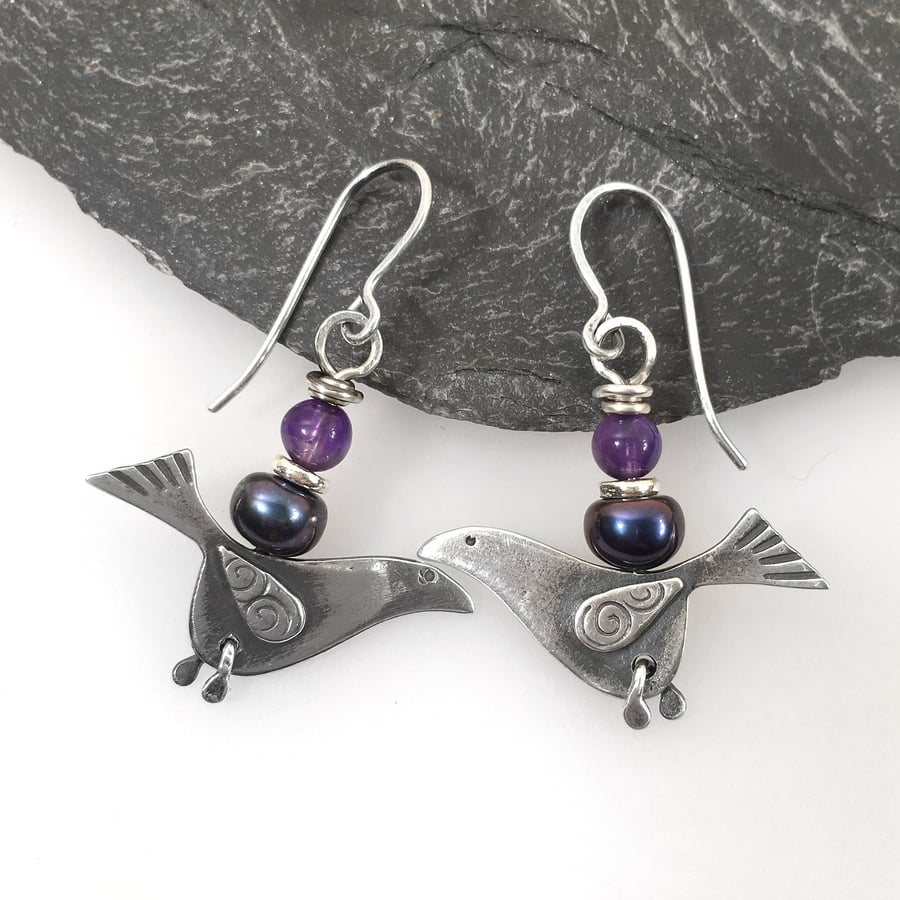 Silver bird earrings with amethyst and black pearl.