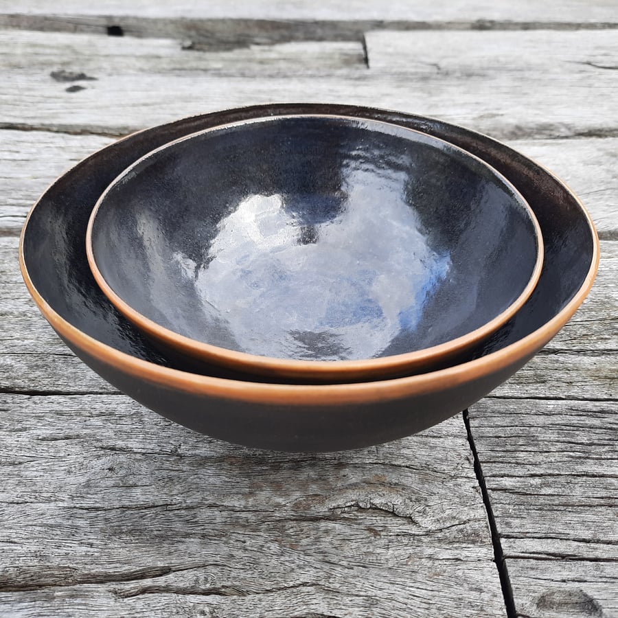 A set of two black clay stoneware large nesting bowls