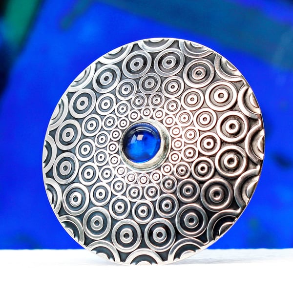 Handmade brooch, descending circle pattern and a beautiful blue Spinel gemstone