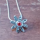 Silver daisy pendant with a red centre 