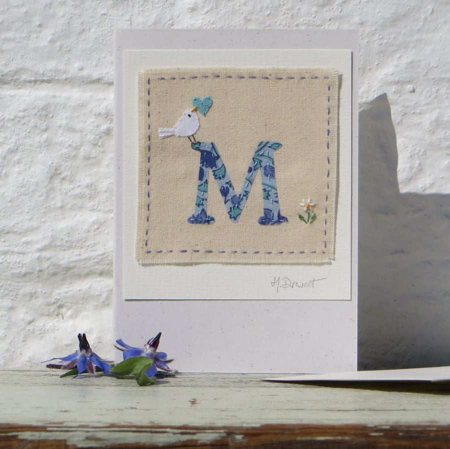 Hand-stitched letter M card with dove, heart and daisy flower