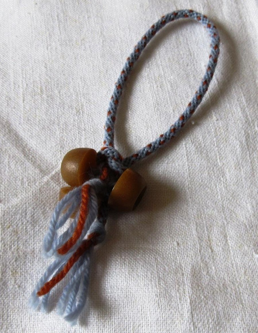 A friendship bracelet in kumihimo braid with a button trim