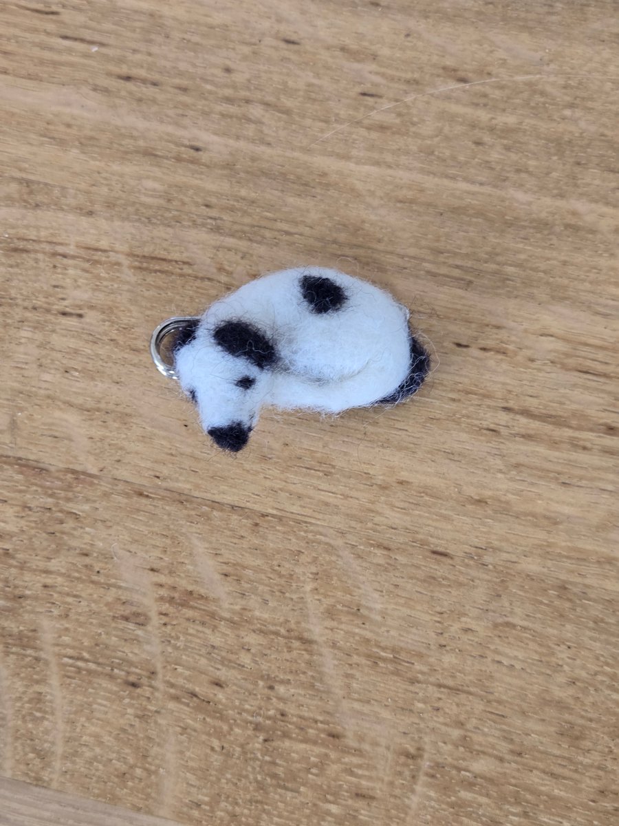 Needle felted black and white dog place on a kilt pin.