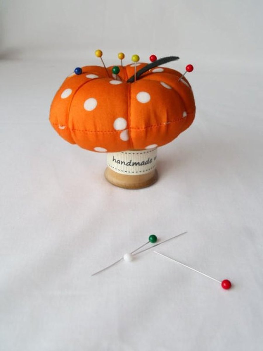 novelty pumpkin pin cushion on a vintage wooden bobbin
