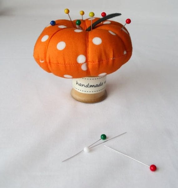 novelty pumpkin pin cushion on a vintage wooden bobbin