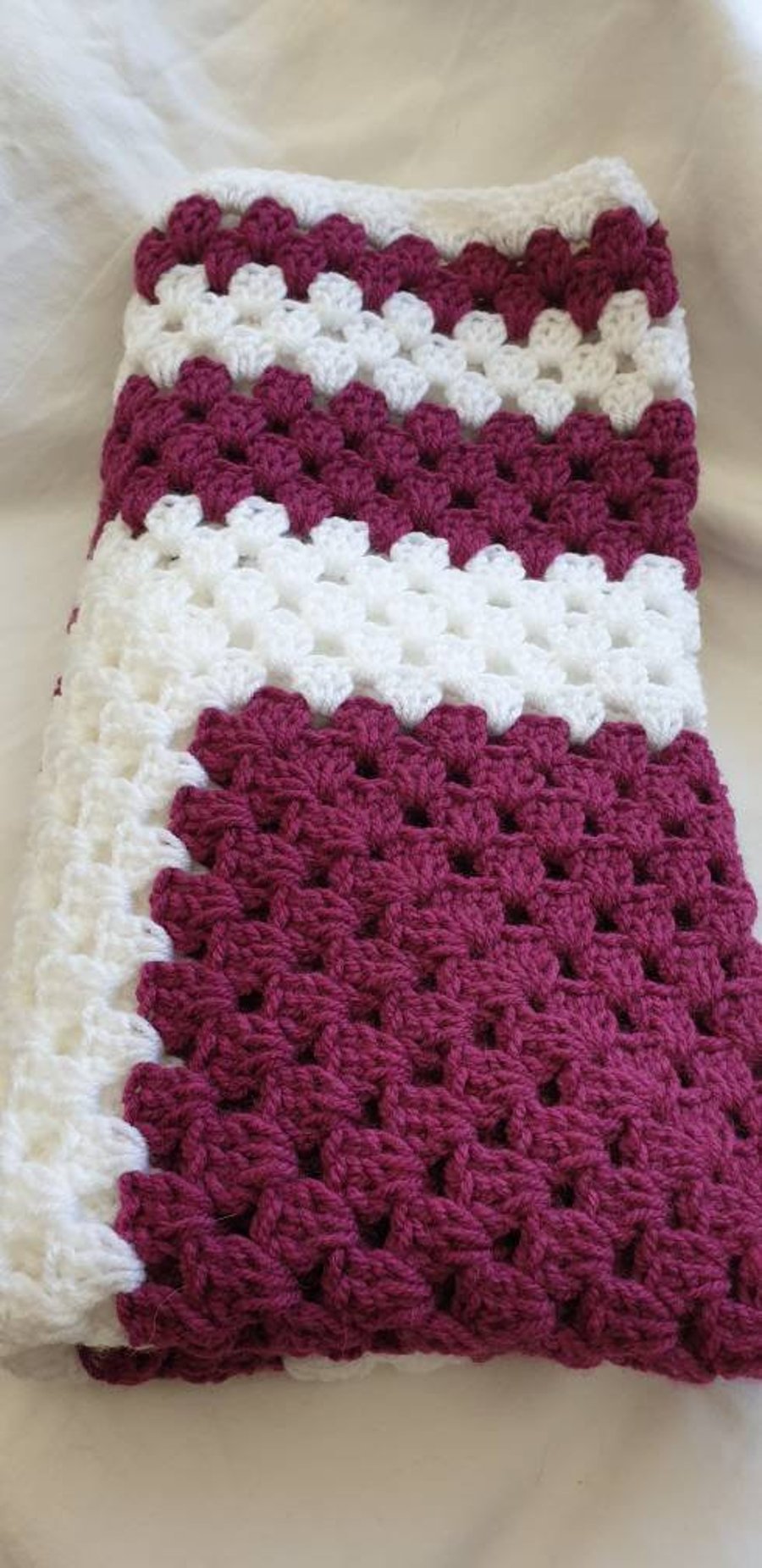 Purple and white granny square crocheted baby blanket