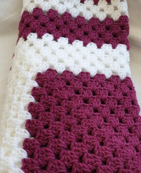 Purple and white granny square crocheted baby blanket