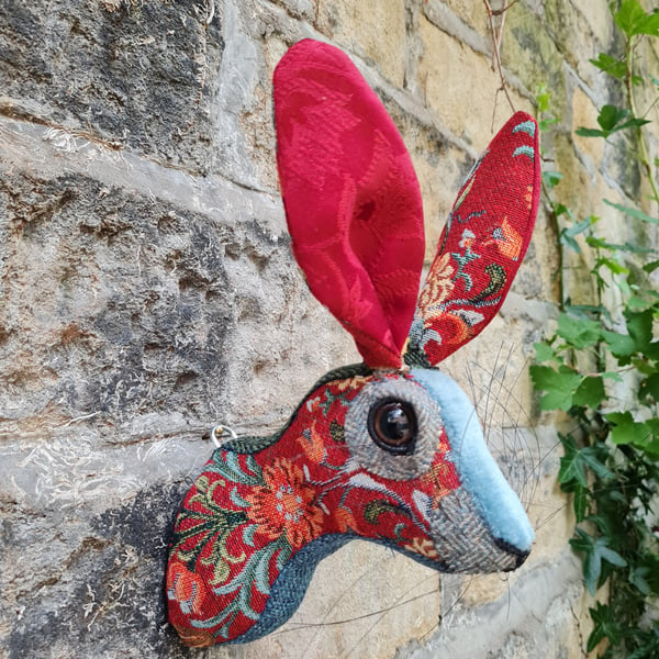 Faux hare head wall mount in red tapestry style fabric