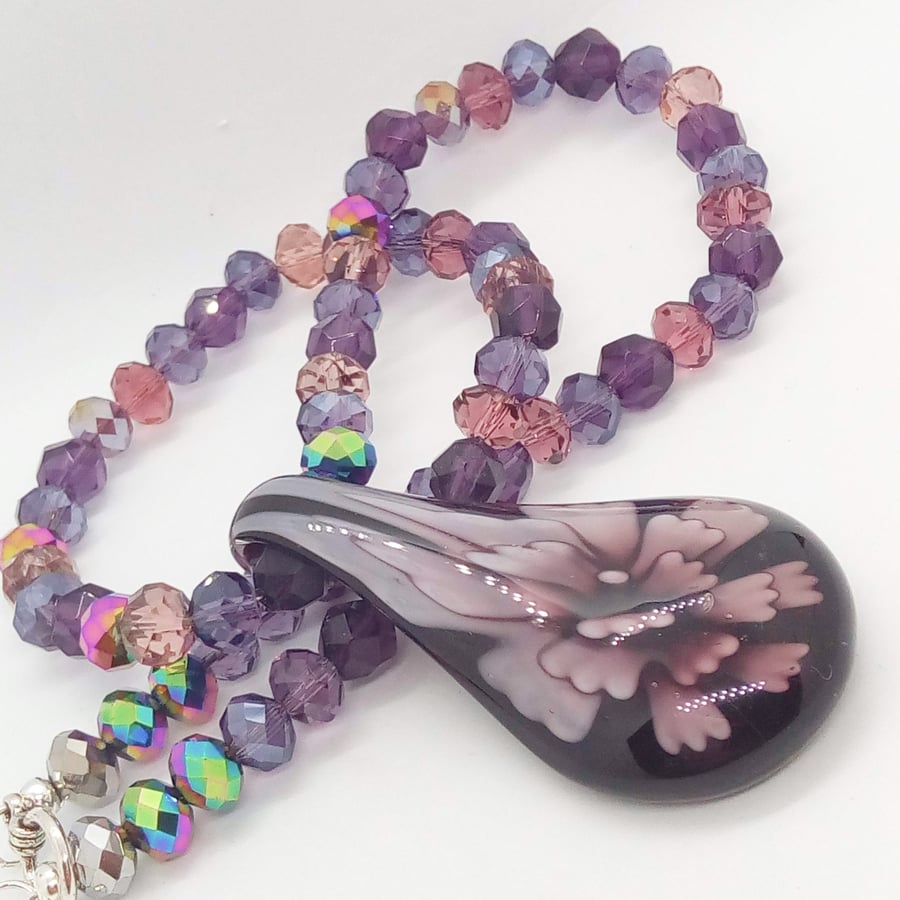 Purple Teardrop Glass Pendant with A Flower Pattern on a Crystal Beaded Necklace