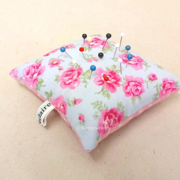 Pin cushion in blue with pink flowers, pink with white spots on the reverse.