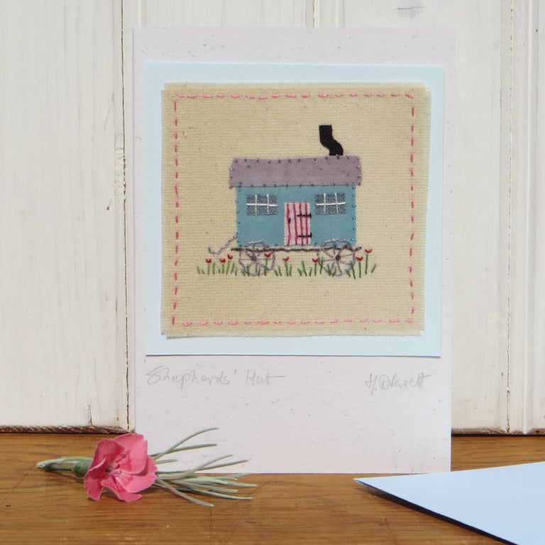 Miniature hand-stitched textile with embroidered details titled 'Shepherd's Hut