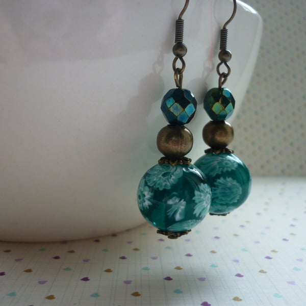 TEAL AND ANTIQUE BRONZE FLORAL GLASS BEAD EARRINGS.