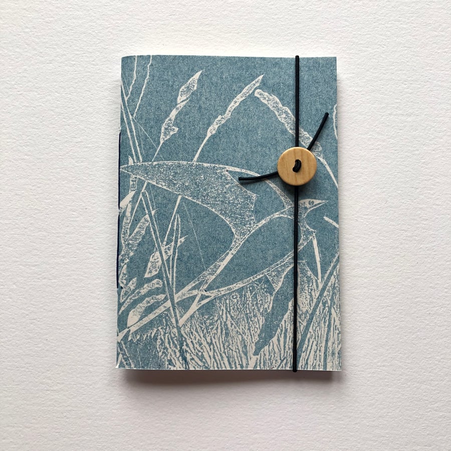 Notebook. Pocket sized. Swallow over grassland.