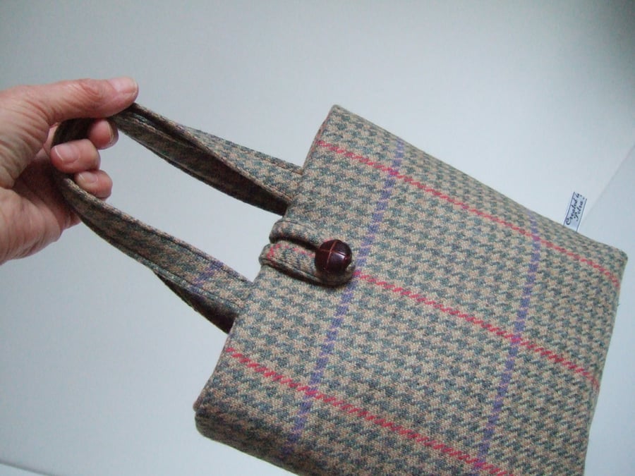 Small woollen bucket bag made from brown and green checked wool.