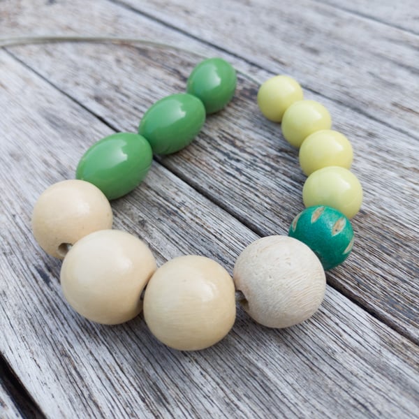 Flori - beaded necklace, olive green, white and yellow with a carved wooden bead