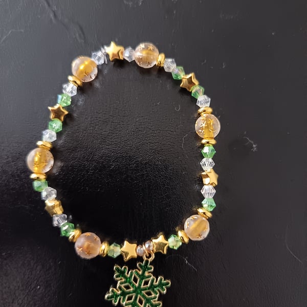 Elasticated beaded green and gold star bracelet with snowflake charm 